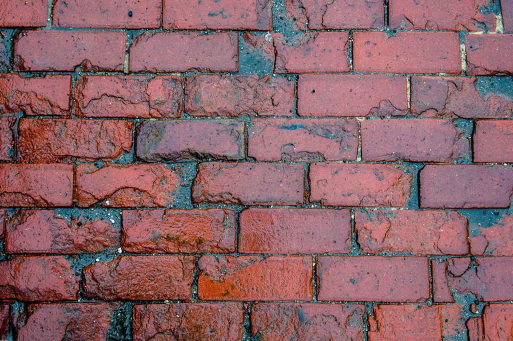 a wet, red brick wall