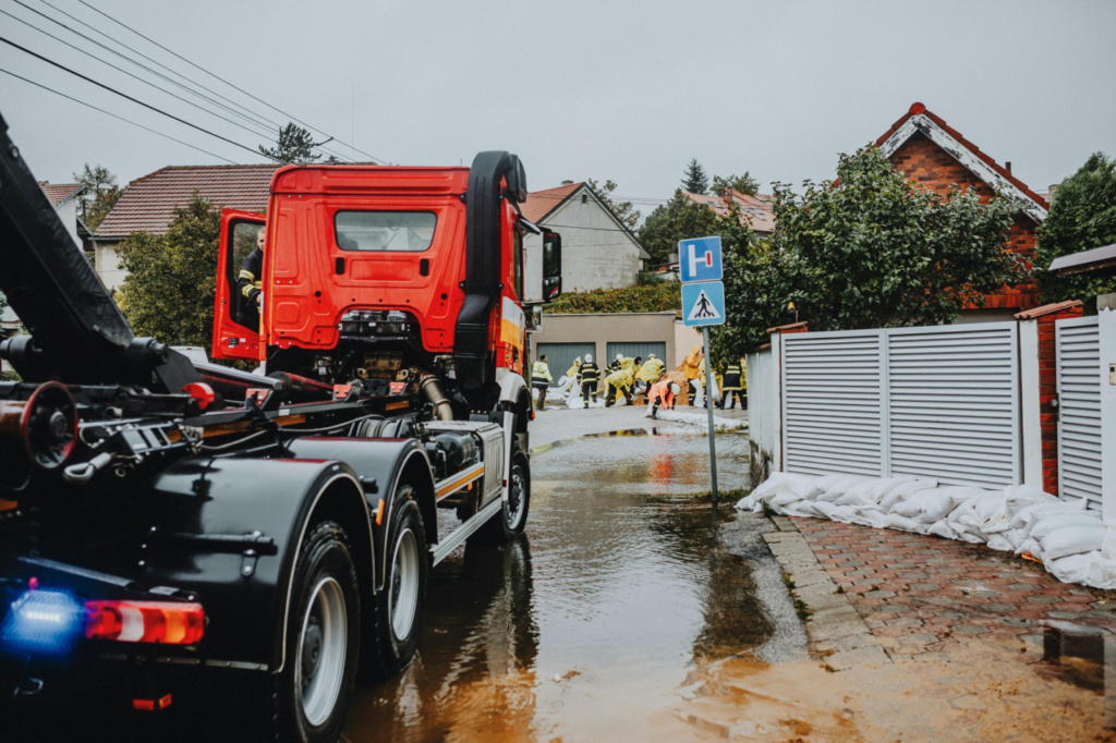 professional service truck and workers working near a flooded area
