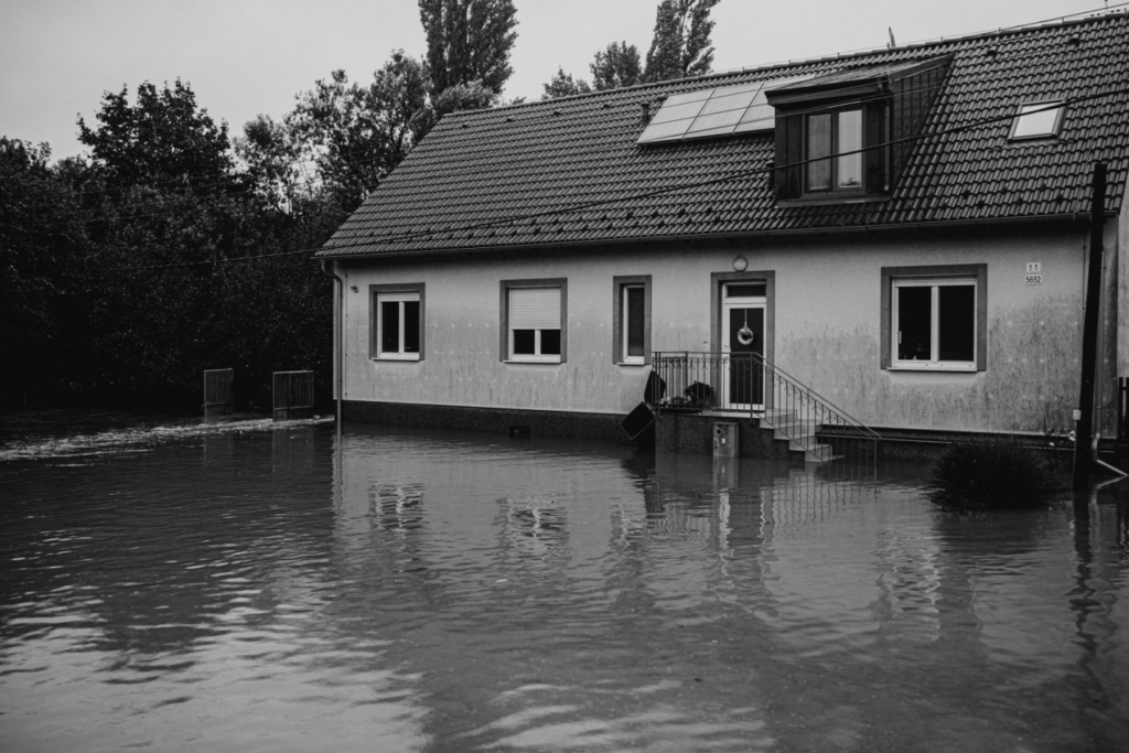 black and white image of a house surrounded by water
