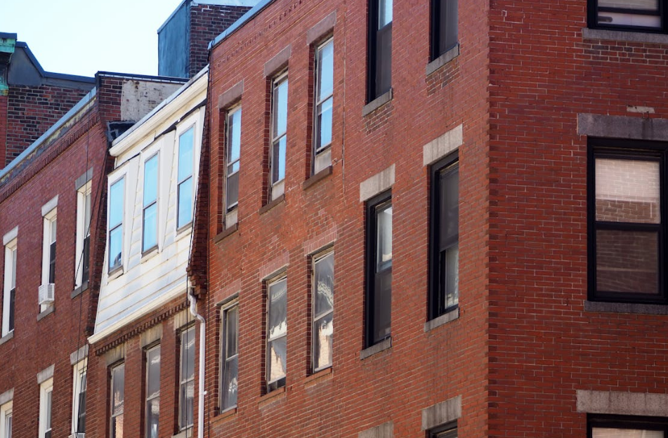 Red brick residential buildings with black window frames in an urban setting