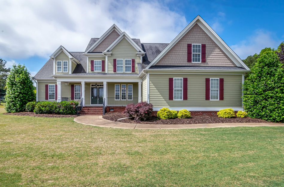 suburban home with a manicured lawn and a curved concrete walkway