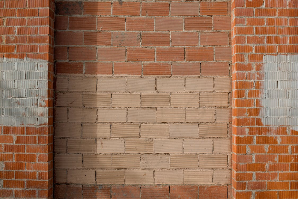 A brick wall with a lighter horizontal section in the middle