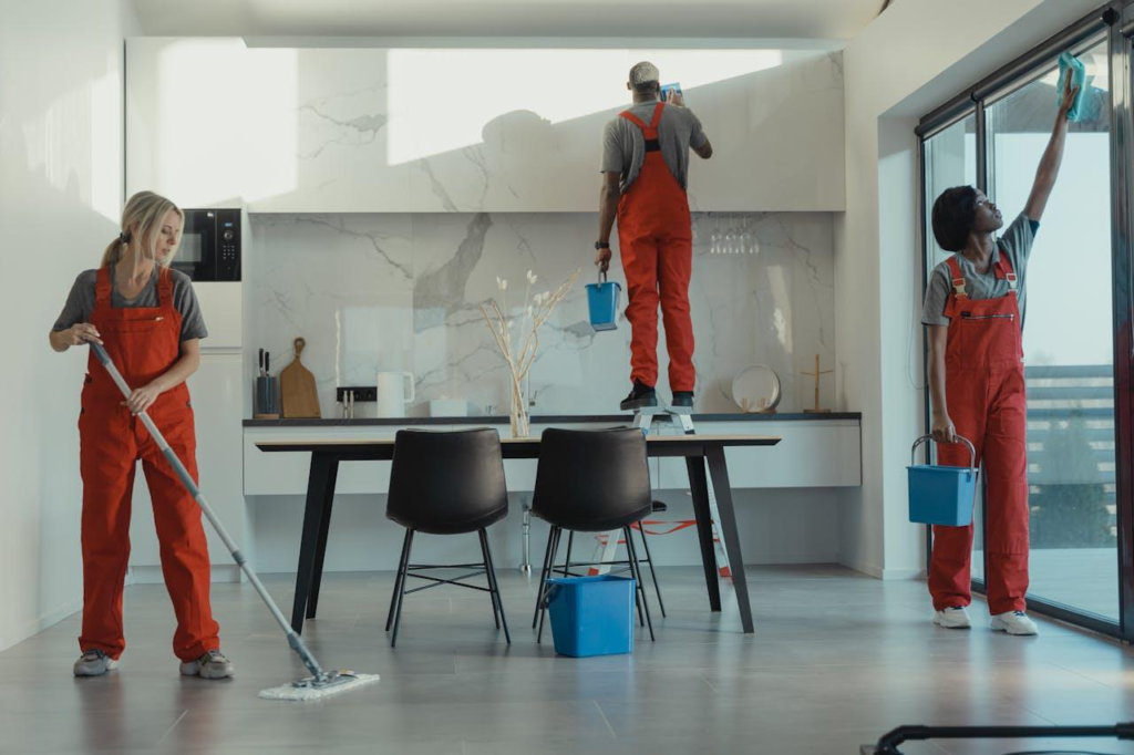 There are 3 workers cleaning the newly polished kitchen