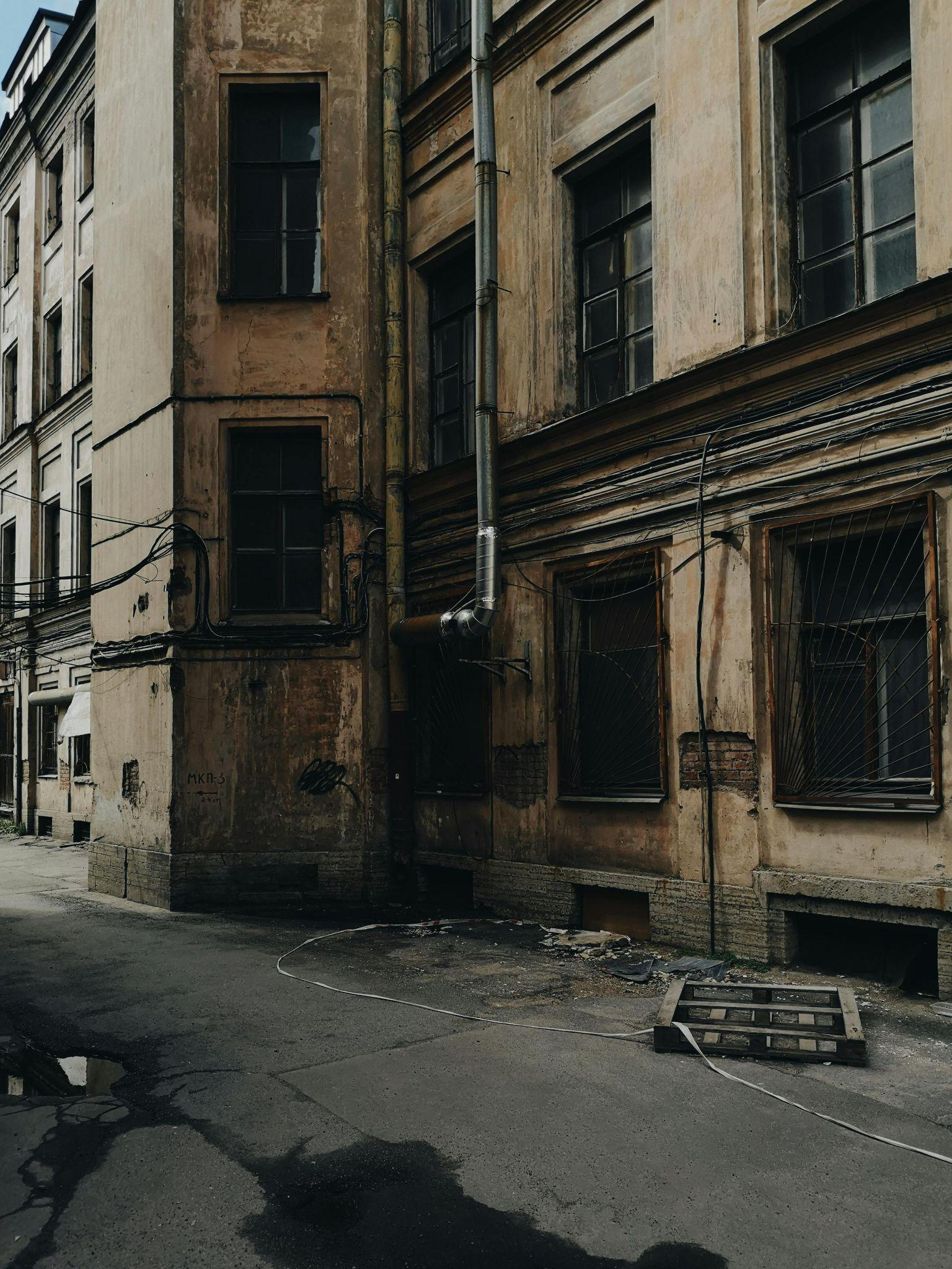 A tall, abandoned concrete building with broken windows