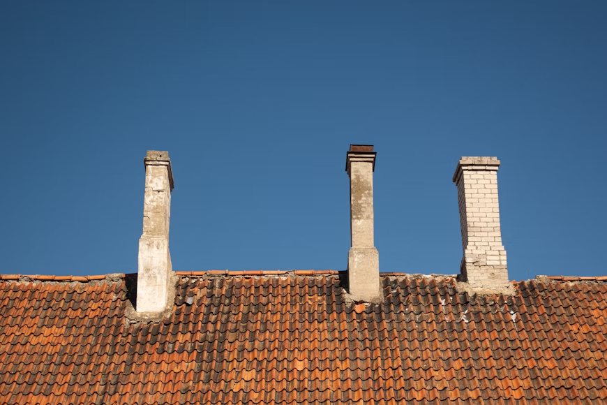 A photo showing a home exterior with worn-down chimneys