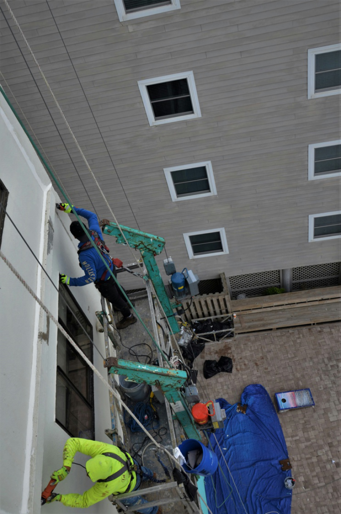 Contractors performing foundation waterproofing in a Greater Boston commercial property.