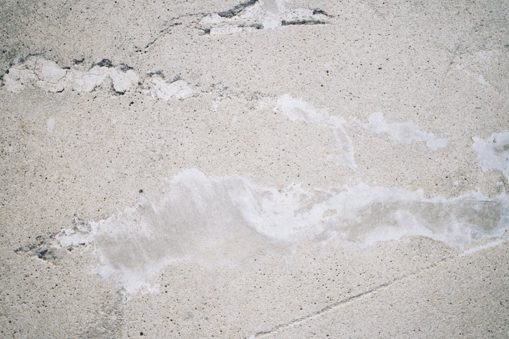  This photo shows a concrete surface with cracks in it.