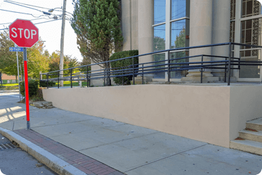 Commercial building exterior with masonry restoration work and upgraded accessibility features along the sidewalk.