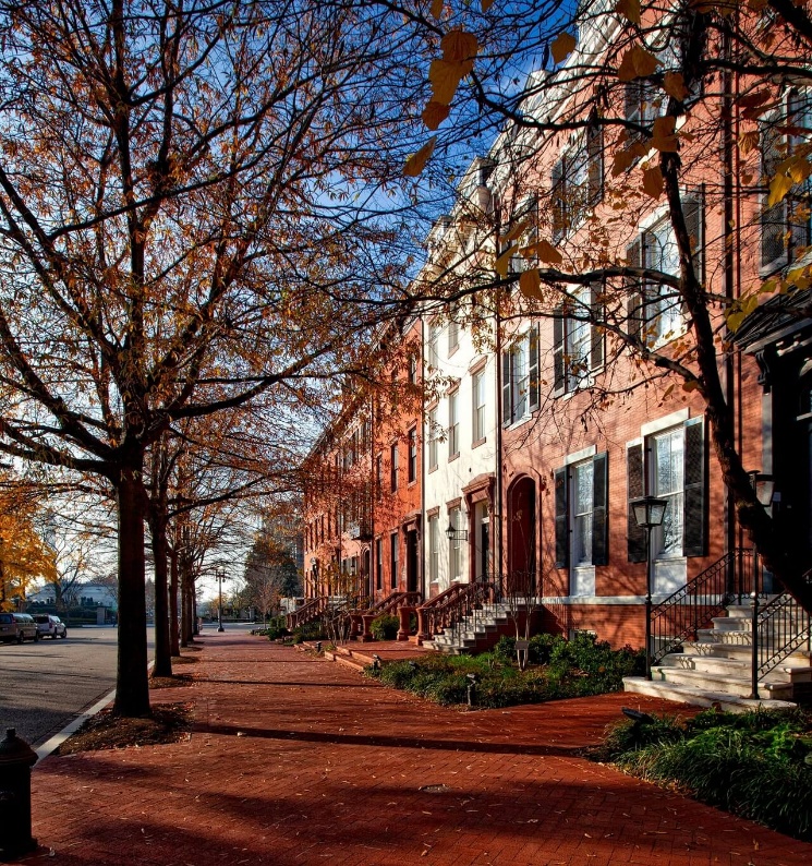Row of masonry buildings in an urban setting showcasing brick facades exposed to years of weather and environmental wear.